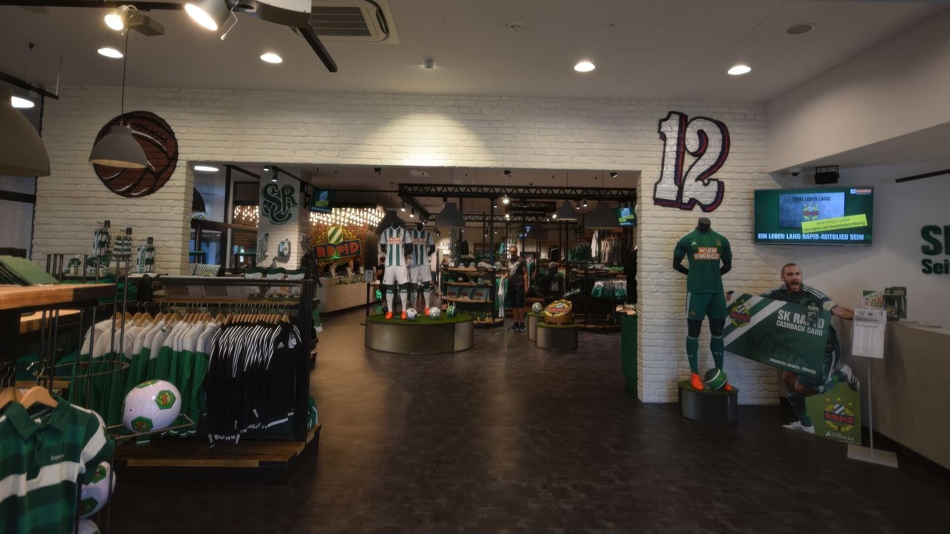 Gesamtansicht des Fanshops mit Verkaufsinseln und Shoparchitektur