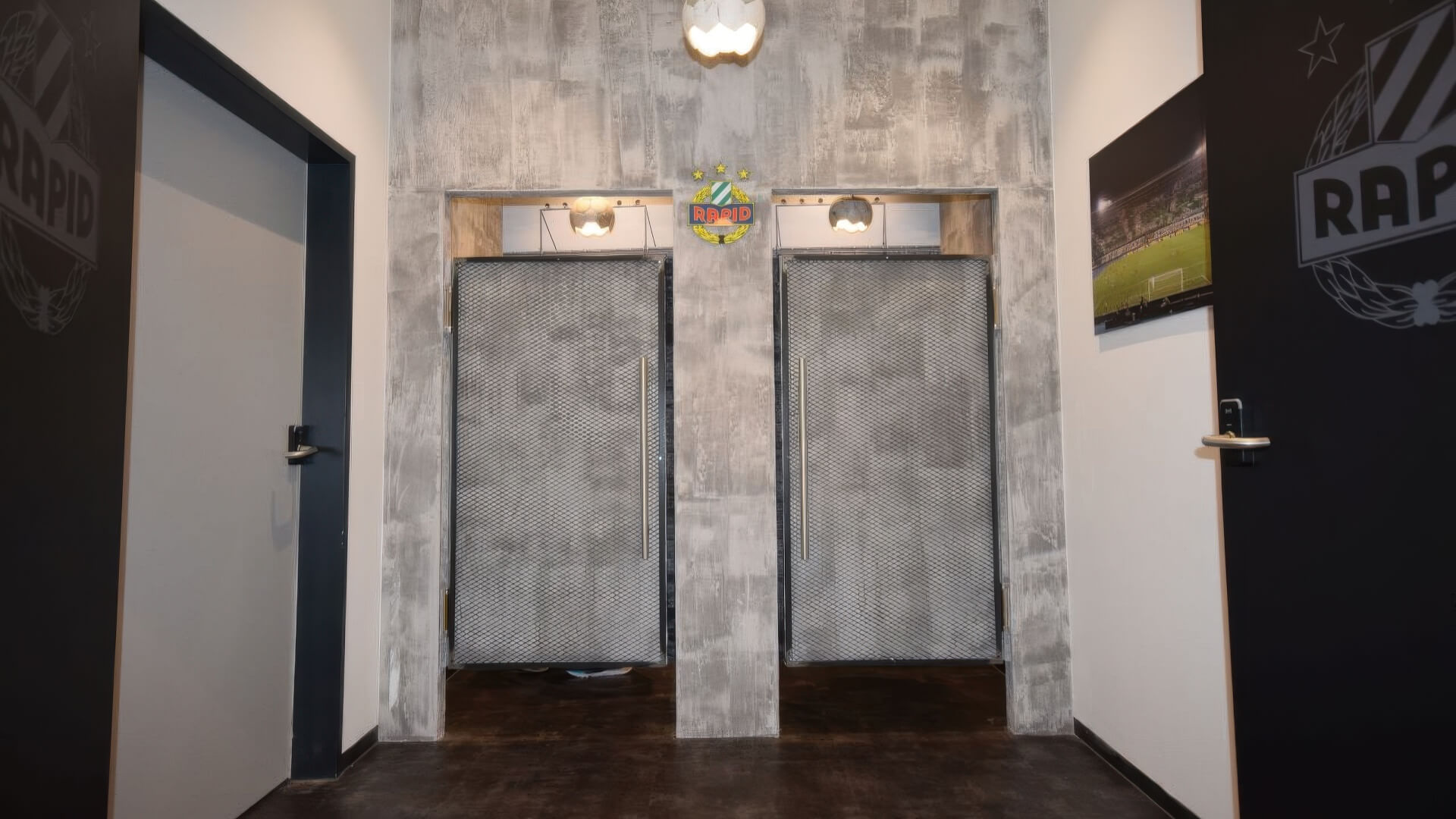 Umkleidezone mit Pendeltüren in Gitteroptik und Betonwand
