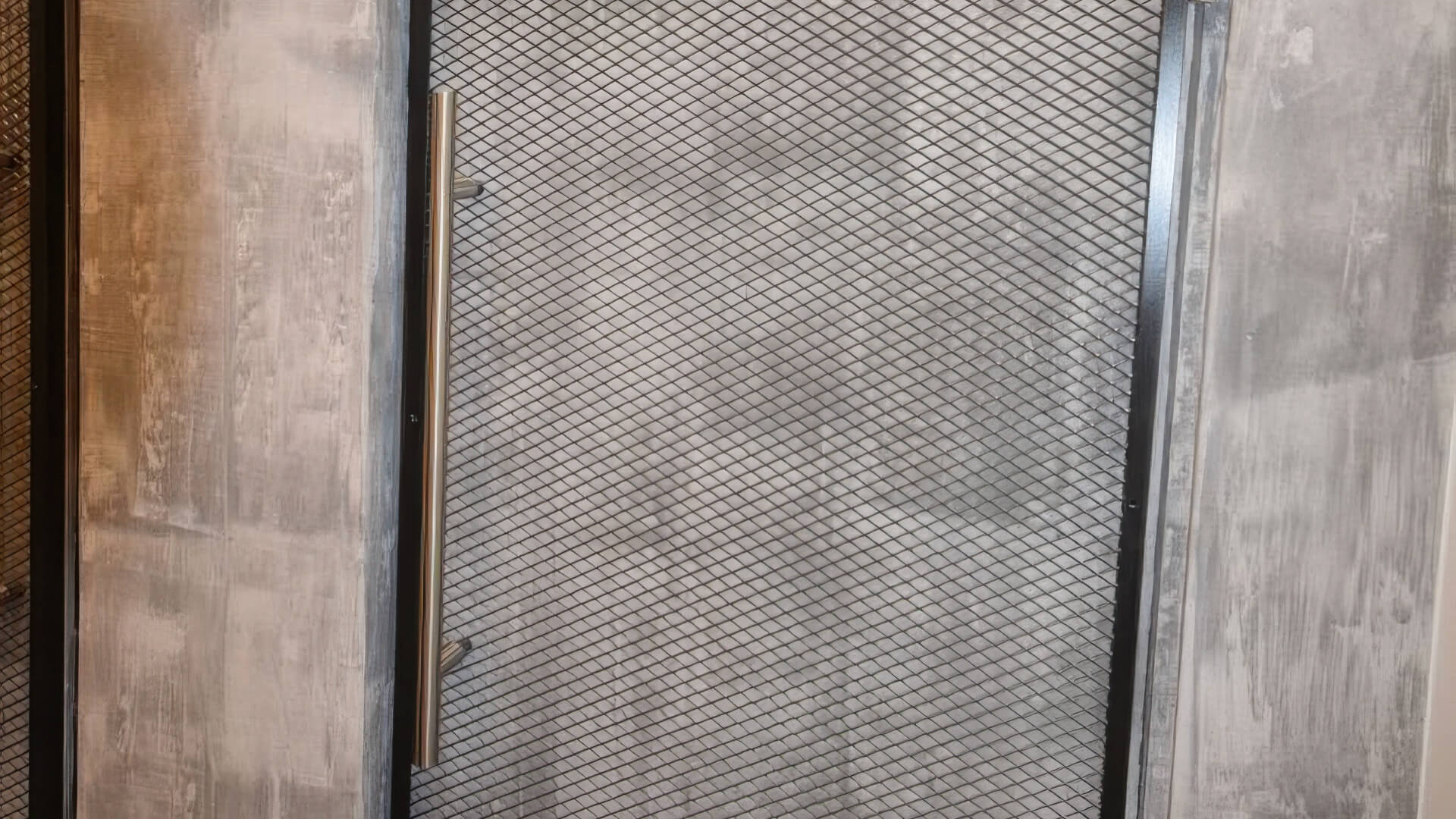 Detail der Gitter-Pendeltür in Metallrahmen