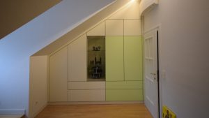 Dachschrägenschrank mit Glasvitrine und Stauraum neben Tür