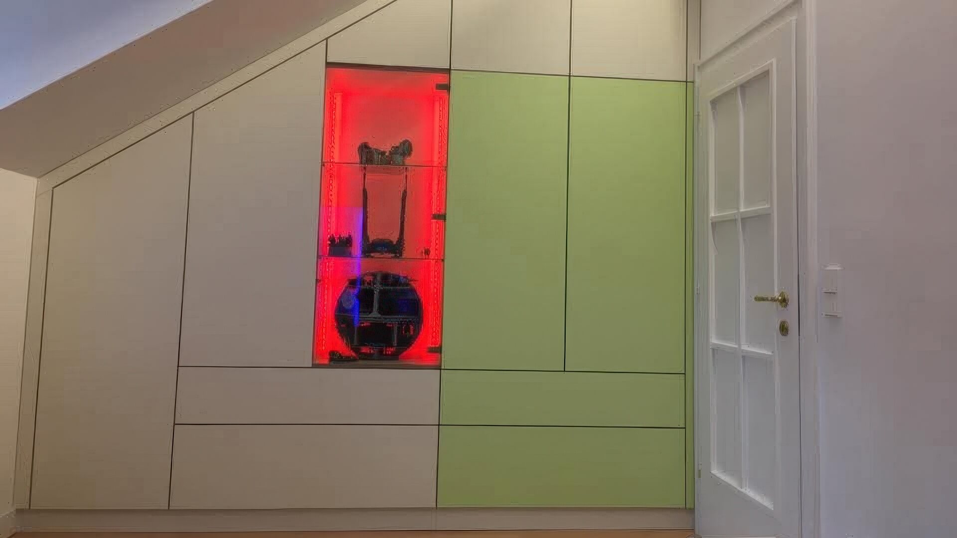 Einbauschrank unter Dachschräge mit LED-beleuchteter Vitrine in Weiß und Hellgrün