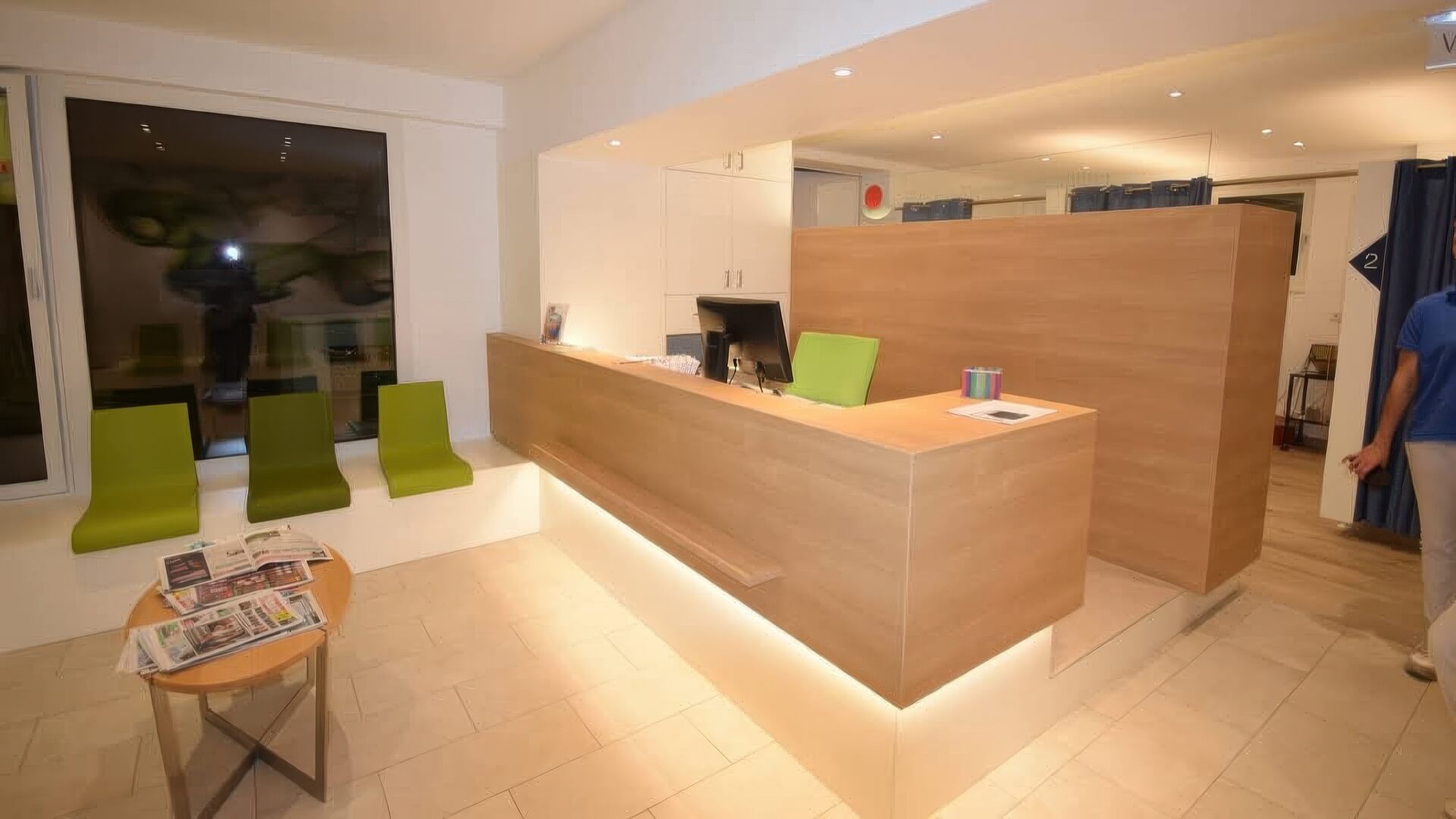 Empfangstheke mit LED-Beleuchtung und Sitzbank im Hintergrund