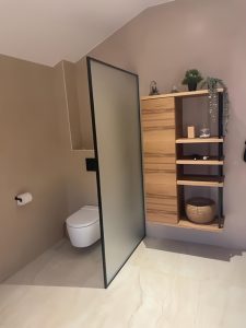 Wandhängende WC-Lösung mit teiloffenem Badezimmerschrank in Eiche