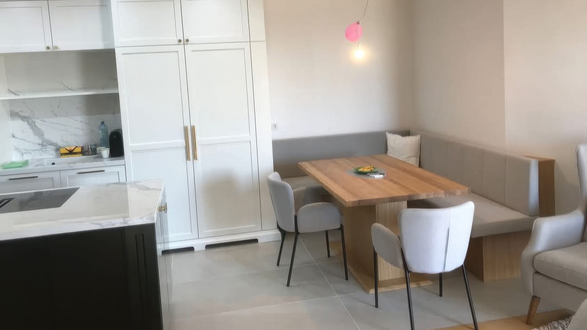Küche mit weißem Hochschrank, Kücheninsel und Essbereich