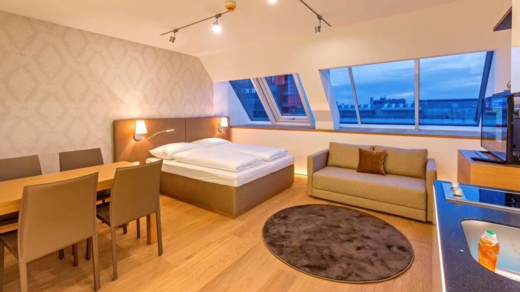 Hotelzimmer mit großem Fenster, Sofa und TV