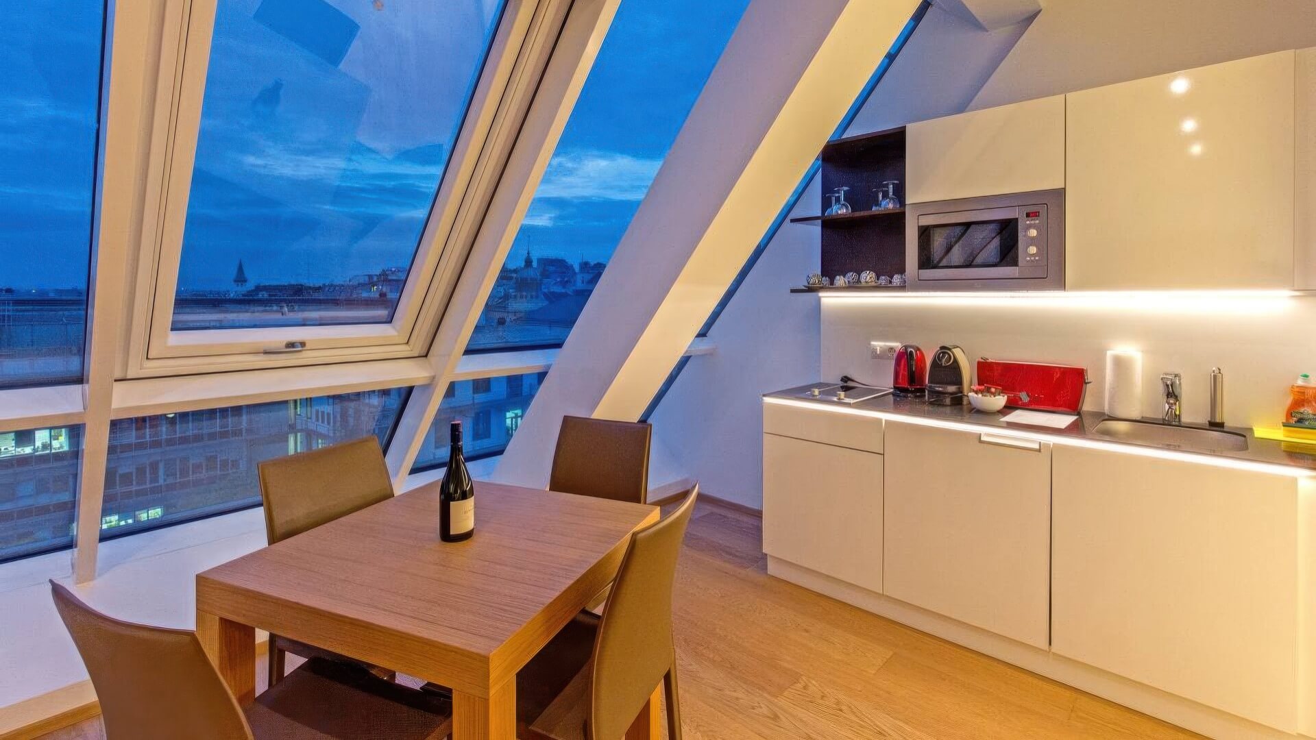 Hotelzimmer mit Küche, Esstisch und Blick über die Stadt