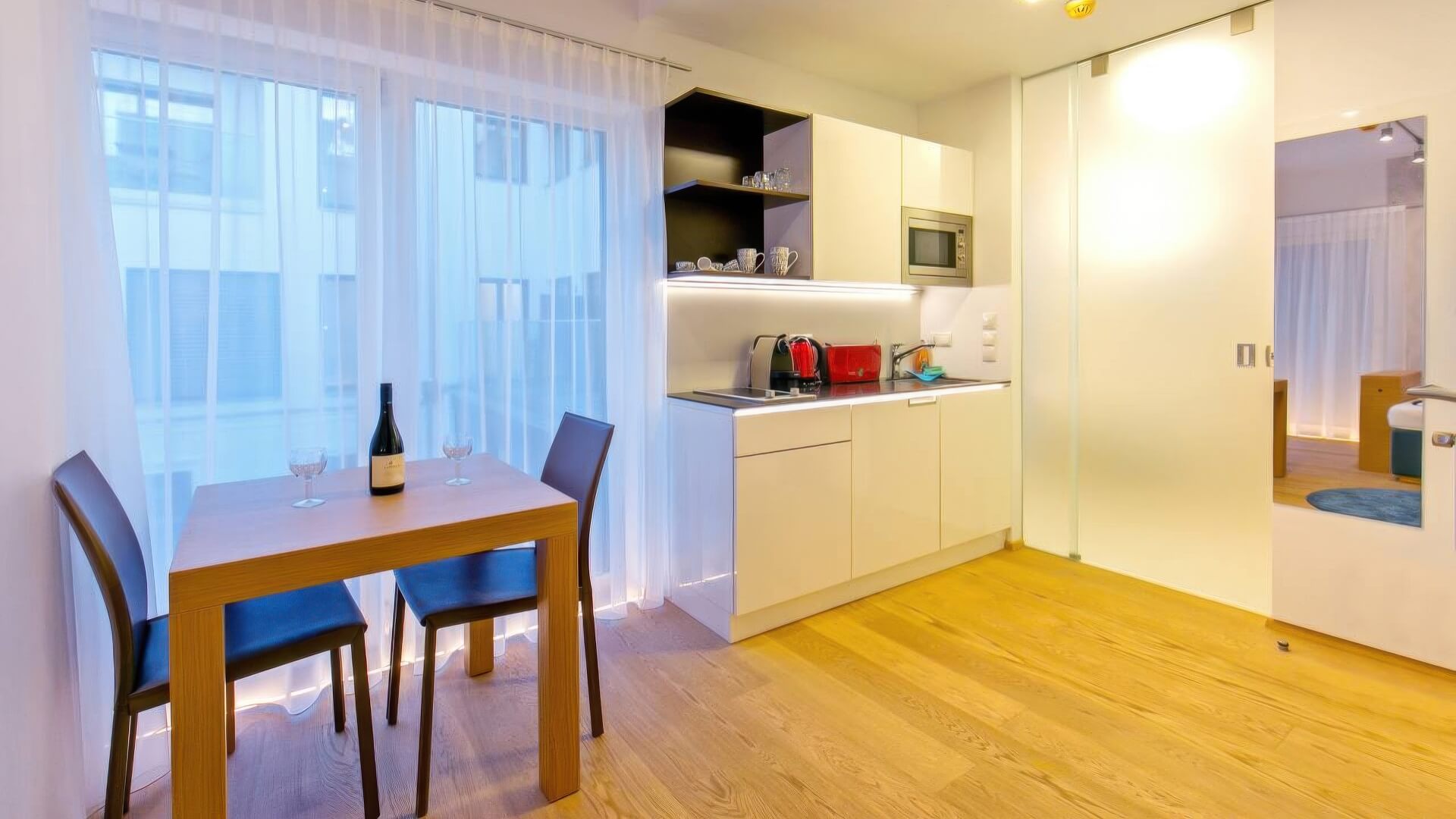 Wohnraum mit Essplatz, Sofa und großflächiger Fensterfront