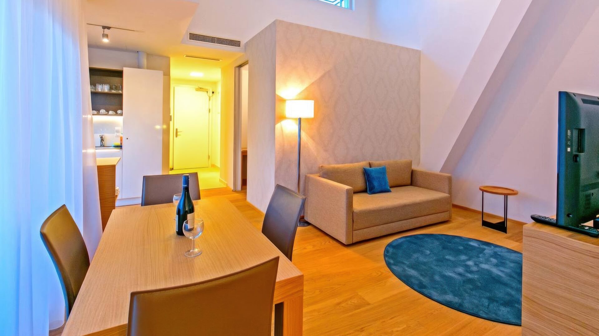 Wohnraum mit Essplatz, Sofa und großflächiger Fensterfront