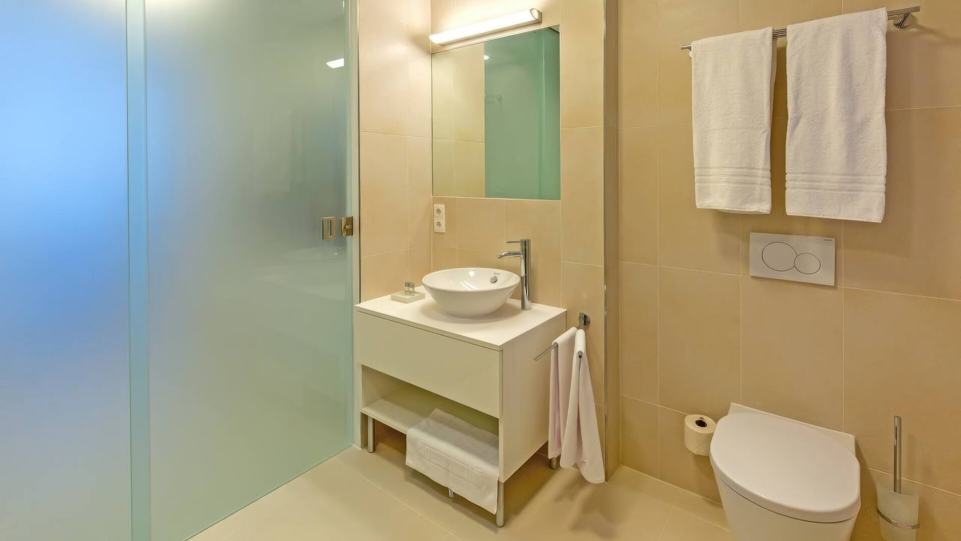 Badezimmer mit Waschtischverbau und Glasdusche