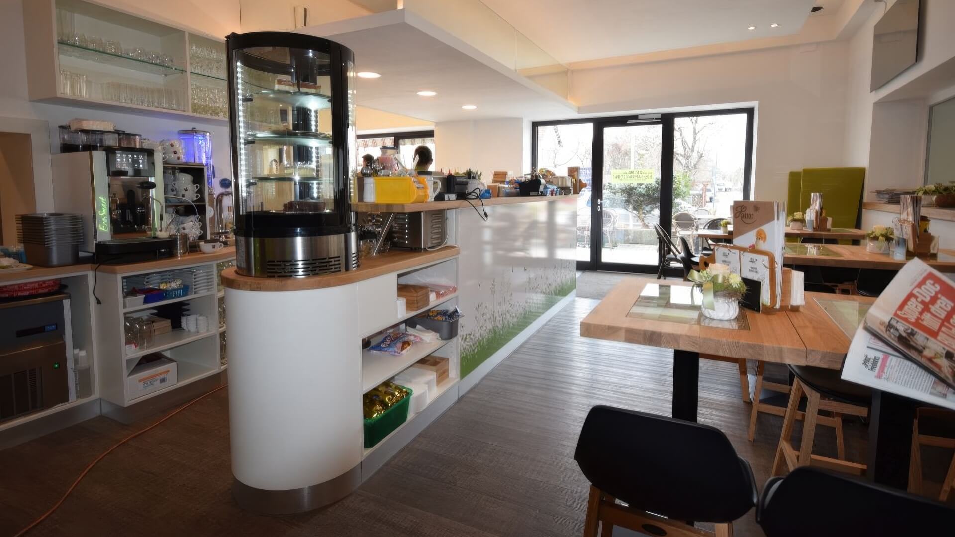 Blick auf den Thekenbereich mit Glasvitrine und weißer Verkleidung
