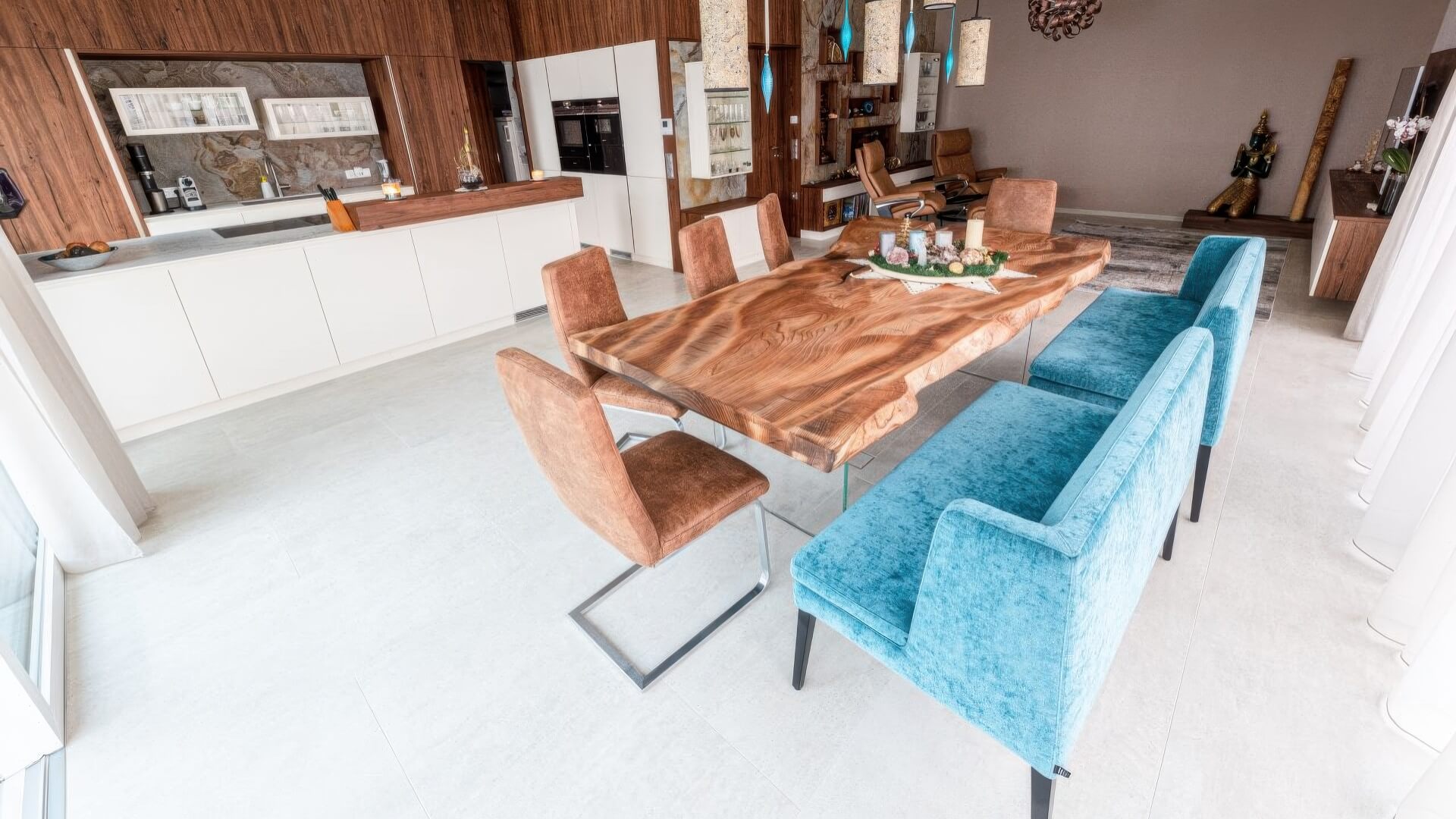 Essbereich mit massiver Holztafel, Stühlen und Blick zur offenen Küche