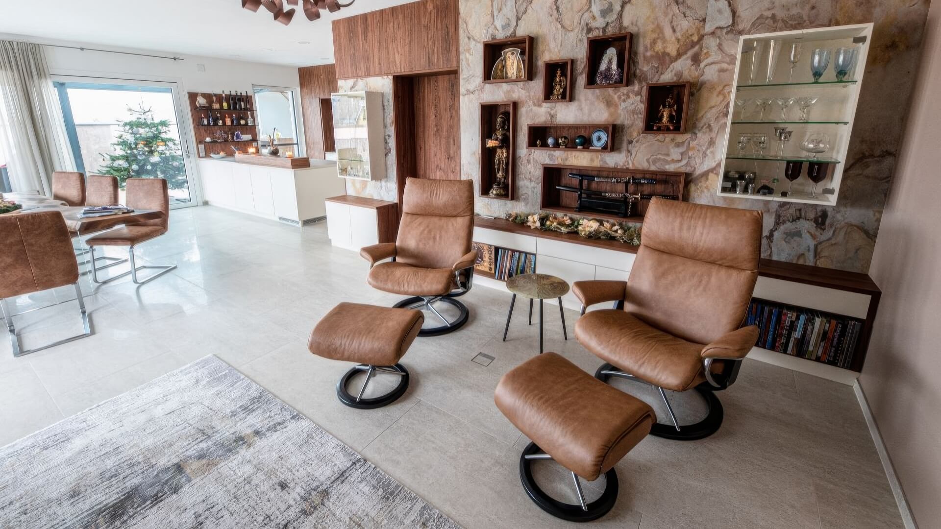 Relaxsessel im Wohnzimmer mit Wandverbau und Vitrinen