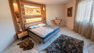 Schlafzimmer mit furniertem Kopfteil, integrierten Nachttischen und Beleuchtung