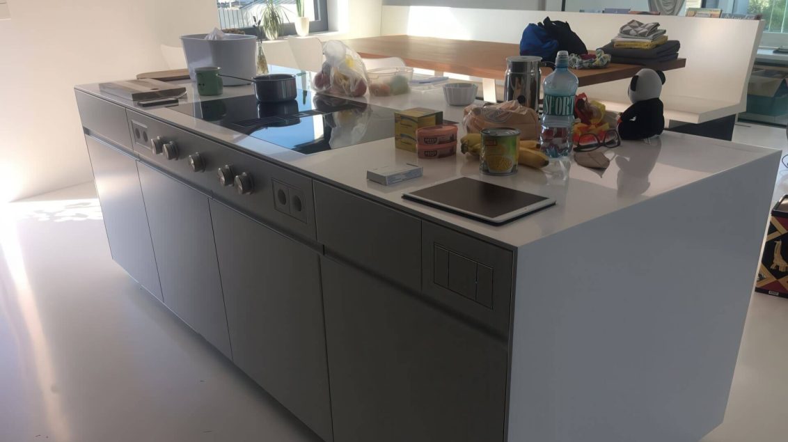 Kücheninsel mit weißer Corian-Arbeitsfläche und Kochfeld