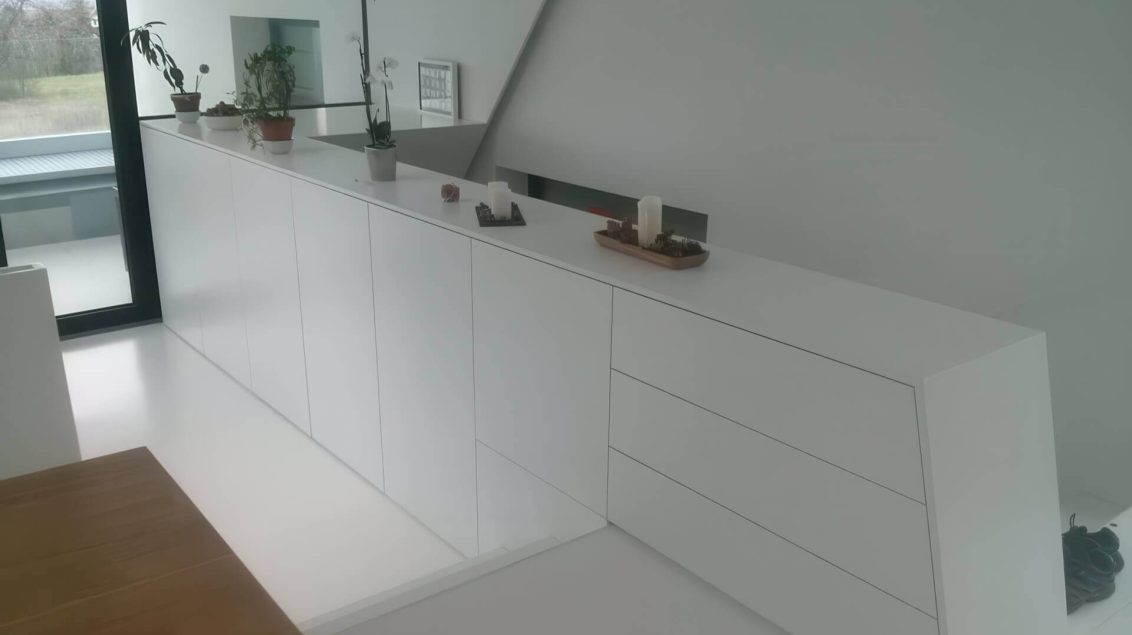 Weiße Stiegenbrüstung mit geometrischem Übergang zur Wand